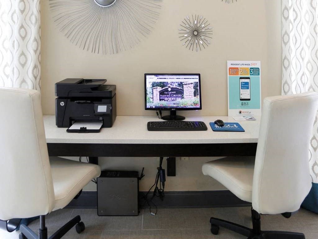 a desk with a computer and a printer on it