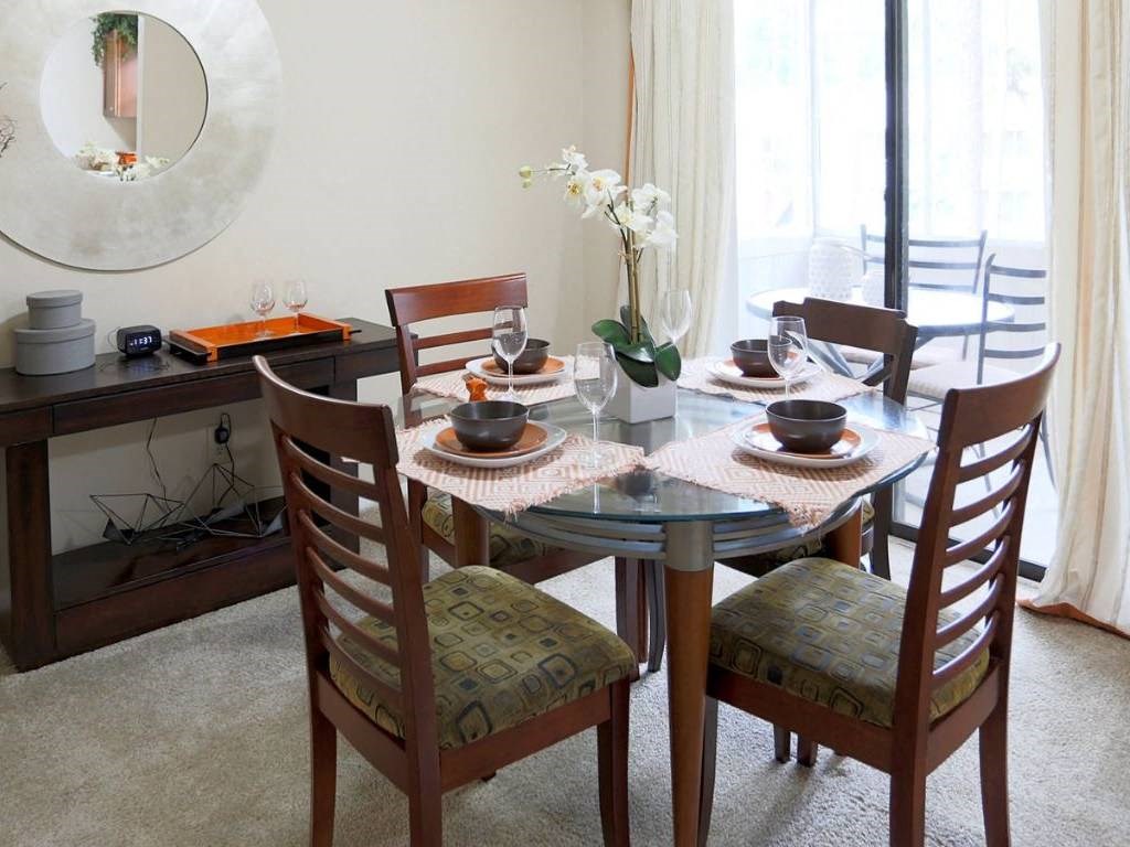 a dining room with a glass table and chairs