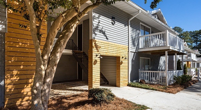 the exterior of a house with a tree in front of it