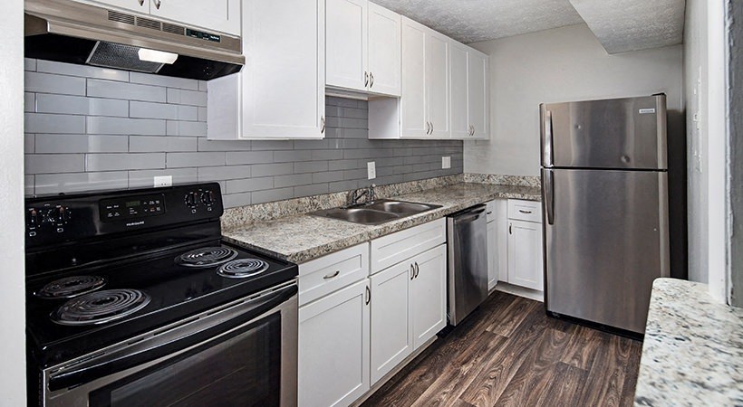 a kitchen with stainless steel appliances and white cabinets