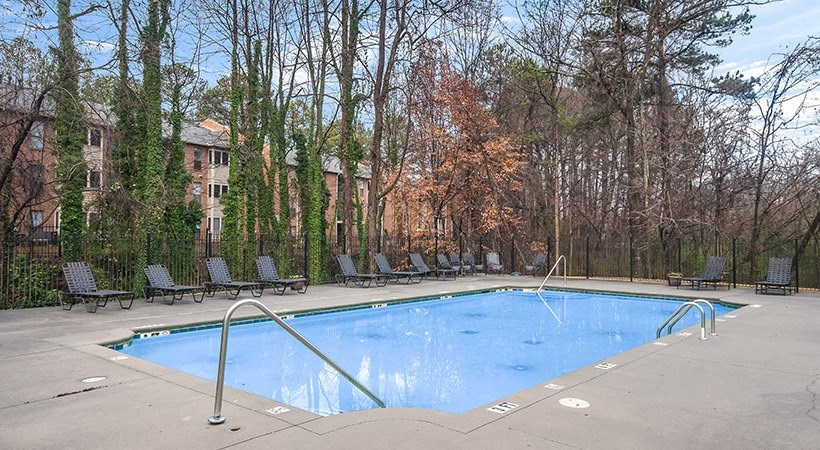 a swimming pool with a row of chairs around it