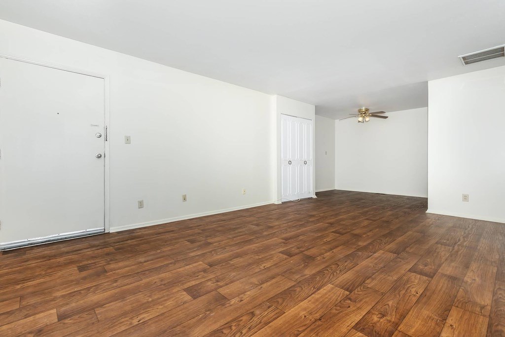 A room with wooden flooring and white walls.