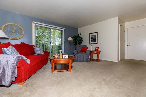A living room with a red couch and a coffee table.