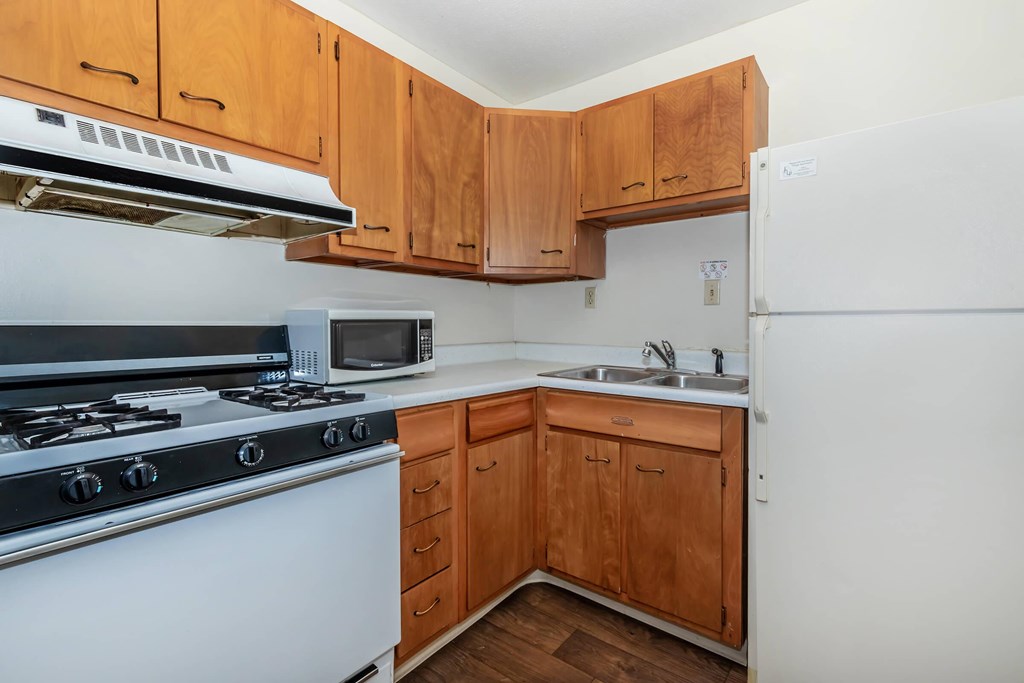 A kitchen with wooden cabinets and a white refrigerator.