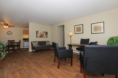 A living room with a grey couch and a wooden floor.
