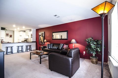 a living room with a red wall and a leather couch