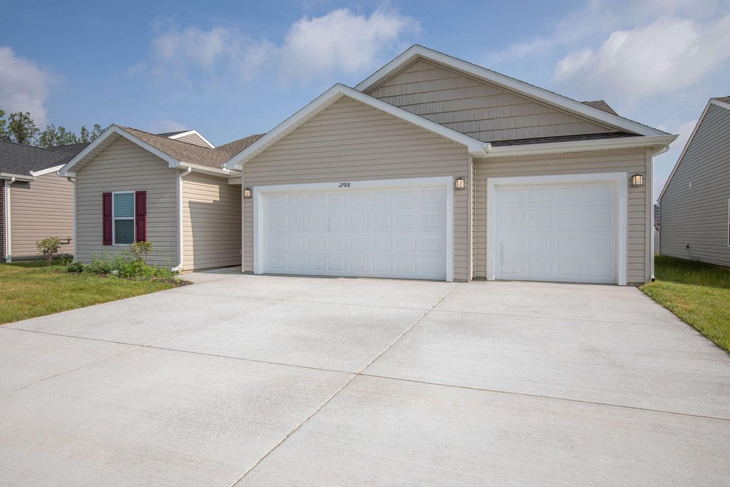 a house with a large driveway and two garages