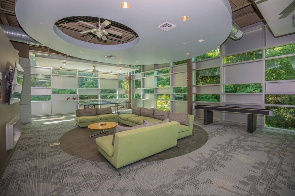 A room with a green couch and a ceiling fan.