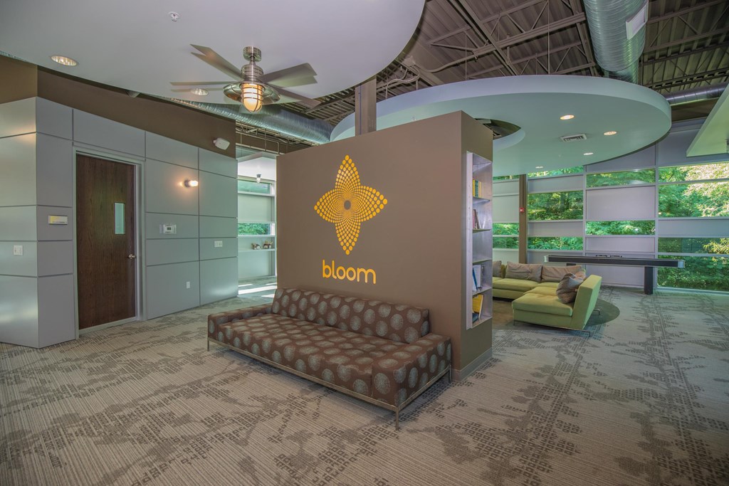 A room with a carpeted floor and a chair with the word bloom on it.