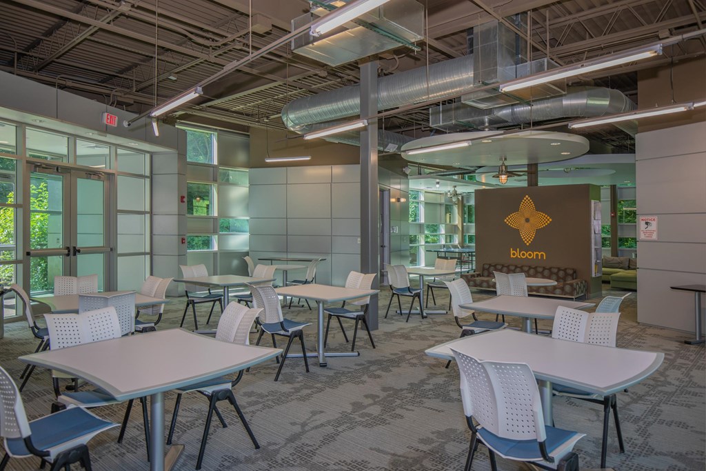 A conference room with tables and chairs and a sign that says bloom.