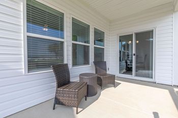 Two chairs and a table are on a patio.