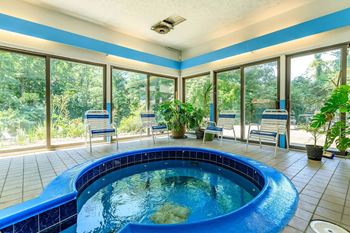 A round blue pool in a room with tiled floors and ceilings.