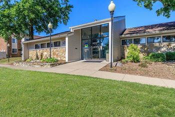 A building with a glass entrance and a stone wall.