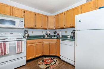 A kitchen with wooden cabinets and white appliances.
