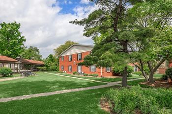 A red brick building with a green lawn in front.