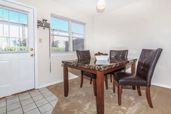 A dining room with a table and chairs.