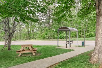 A picnic area with a table and benches under a shelter.