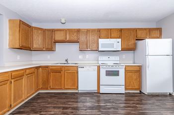 A kitchen with wooden cabinets and white appliances.