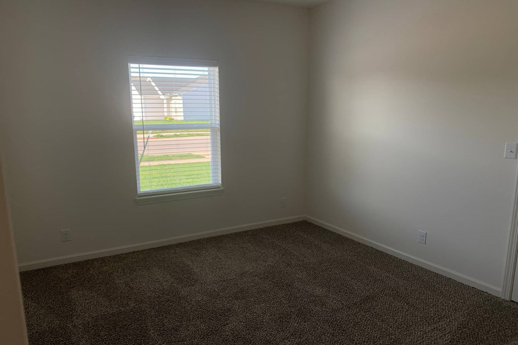 a small empty room with a window in the corner