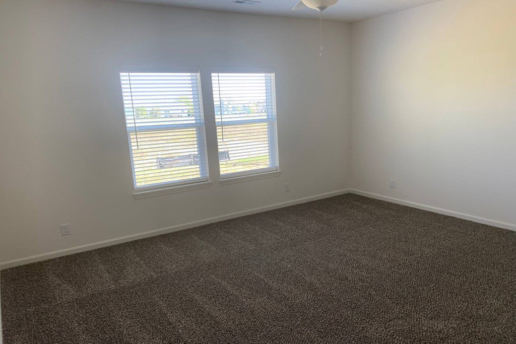 an empty room with two windows