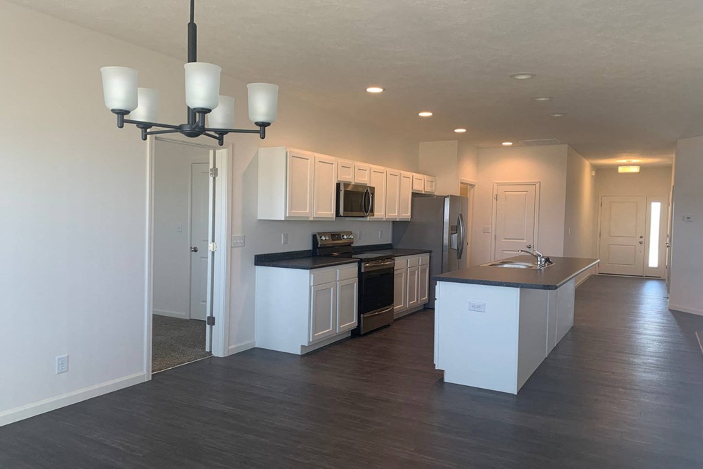 a kitchen with white cabinets and black countertops