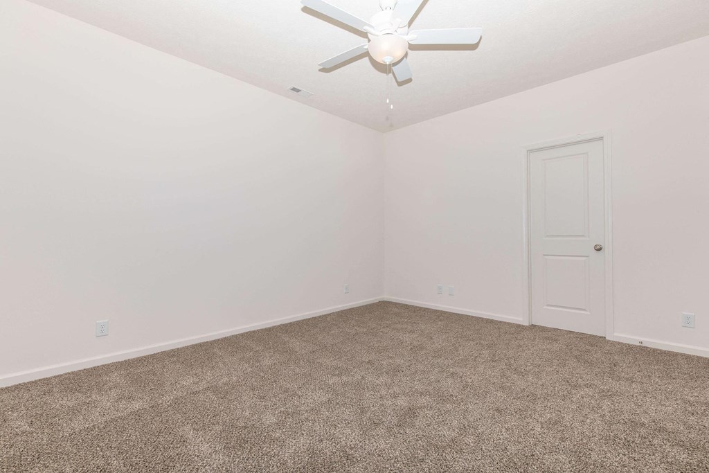 a bedroom with white walls and carpet