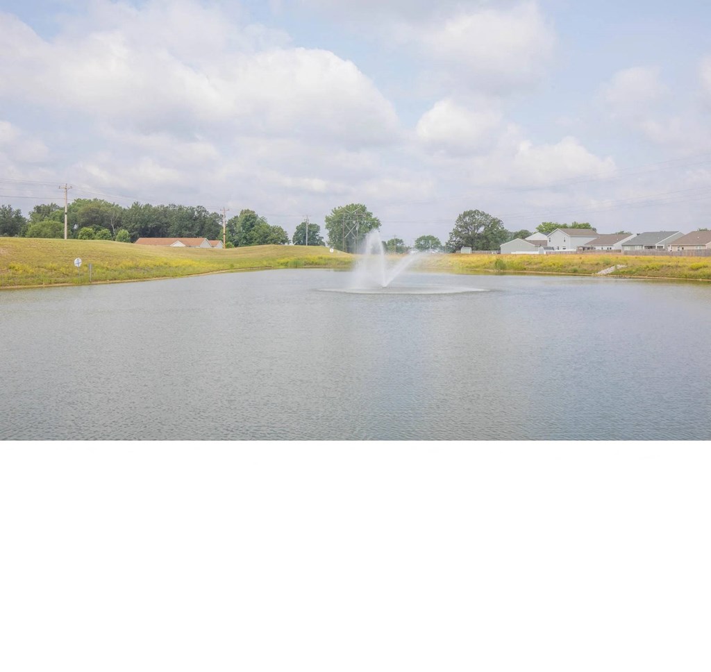 a large pond with a fountain in the middle of it