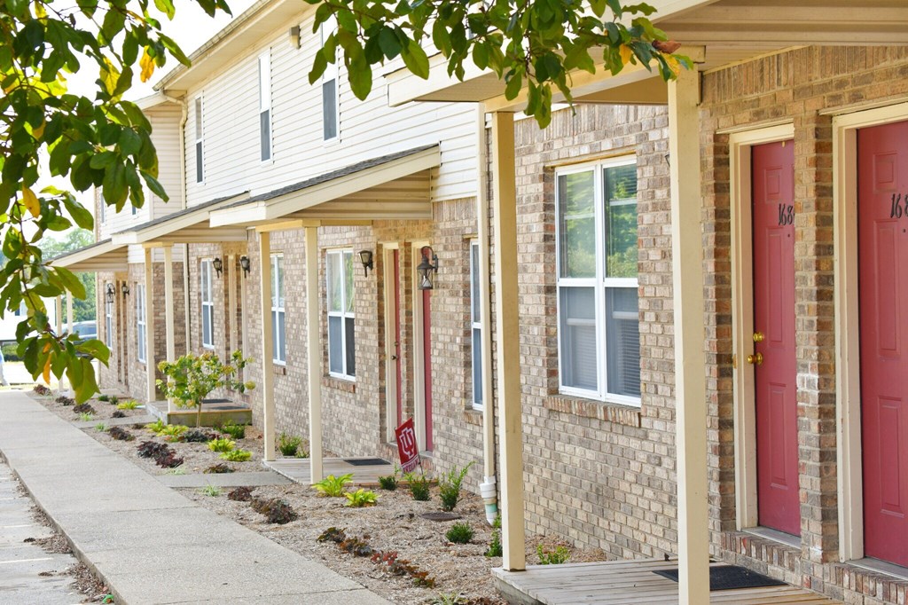 A row of houses with red doors and windows.