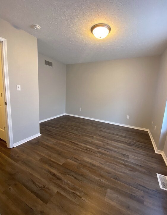 A room with wooden flooring and a ceiling light.