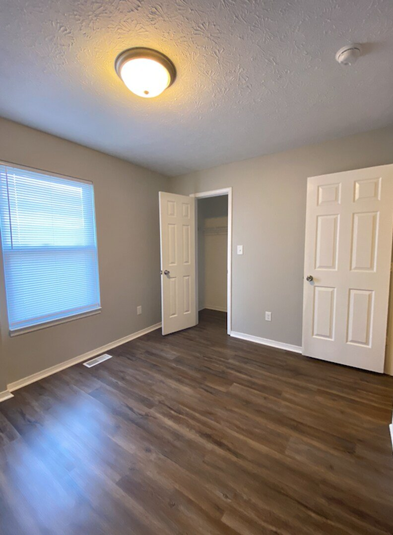A room with a wooden floor and white walls.