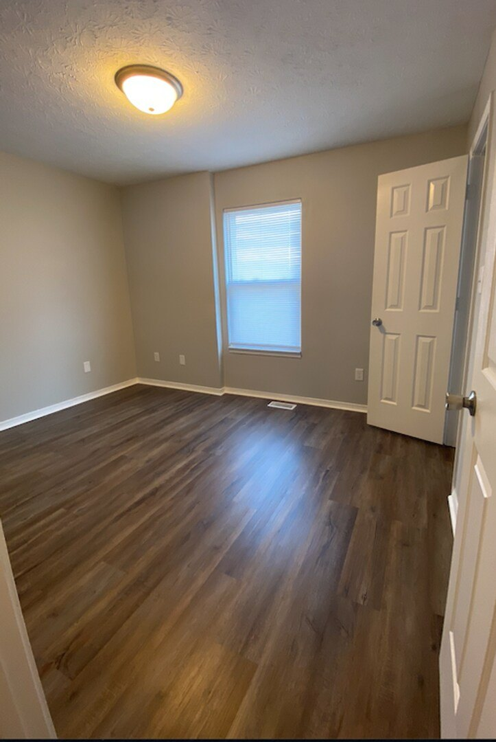 A room with wooden floors and a white door.