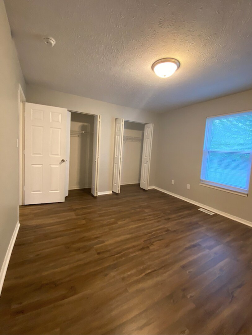 A room with wooden floors and a white door.