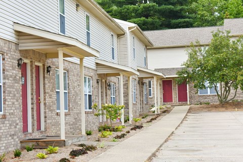 A row of houses with red doors and windows.