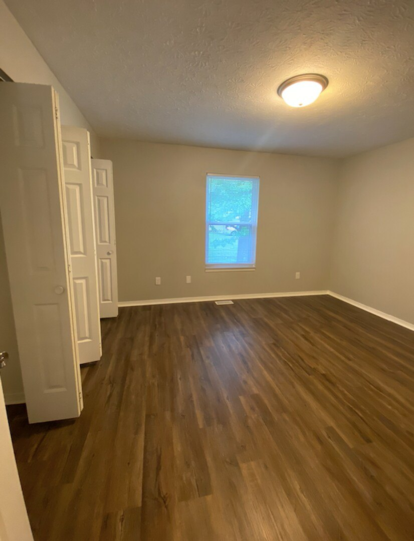 A room with wooden flooring and a window.