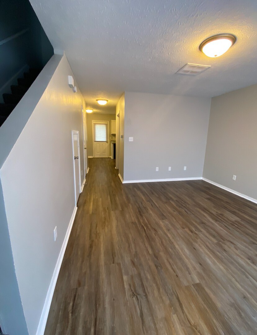 A hallway with wooden floors and a light on the ceiling.