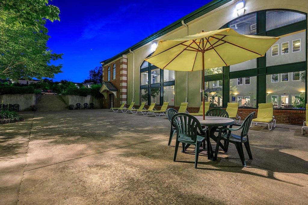 A yellow umbrella is on a table outside a building.