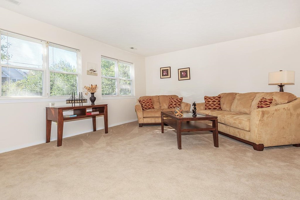 A living room with a couch, two chairs, and a coffee table.