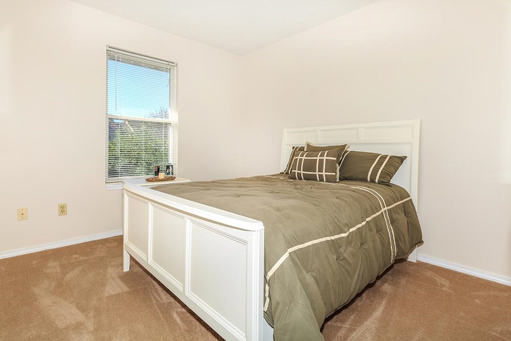 A bedroom with a large bed and a window.