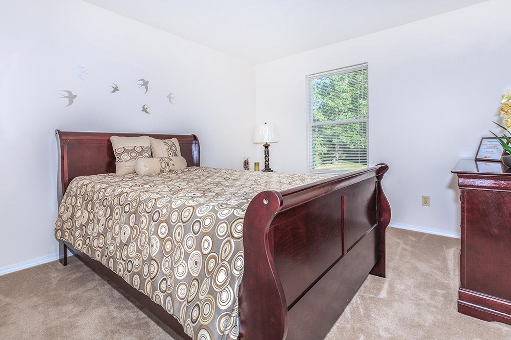 A bedroom with a large bed and a window.