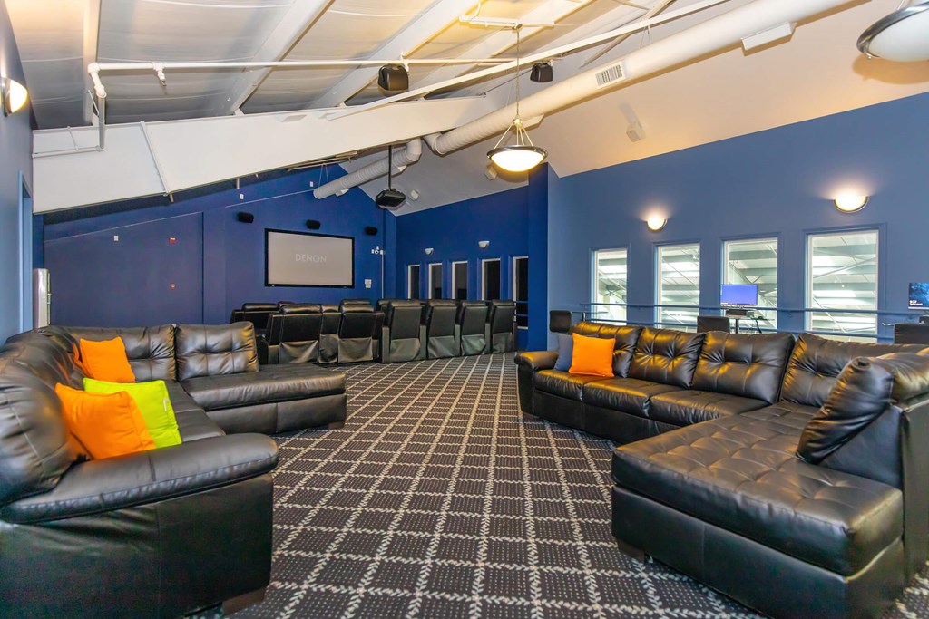 A room with black leather couches and a checkered floor.