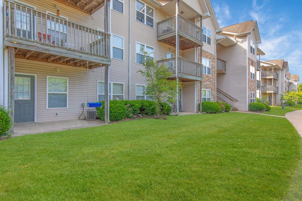 Apartment complex with green grass in front.