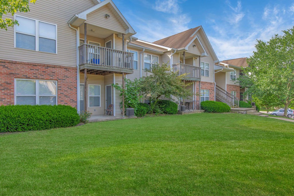 A large grassy area in front of apartment buildings.
