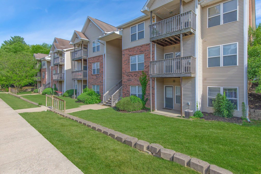 Apartment complex with a grassy area in front.