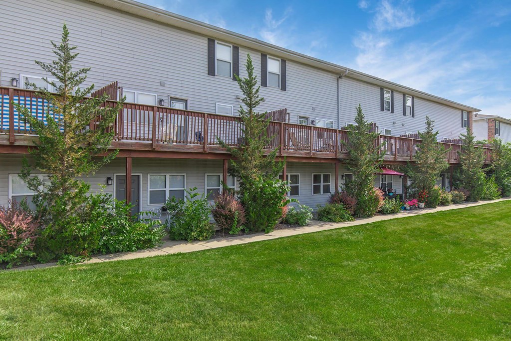 A row of houses with green lawns in front.