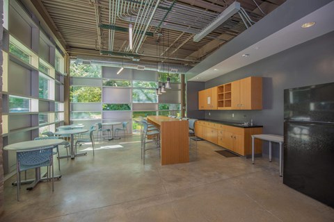 A kitchen with a black refrigerator and wooden cabinets.