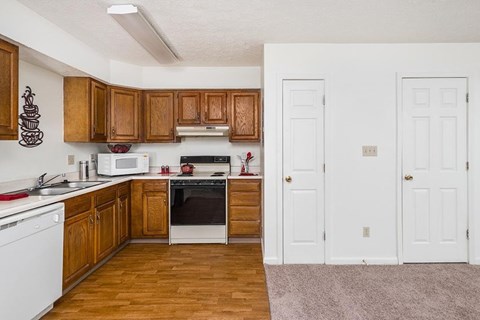 A kitchen with wooden cabinets and white appliances.
