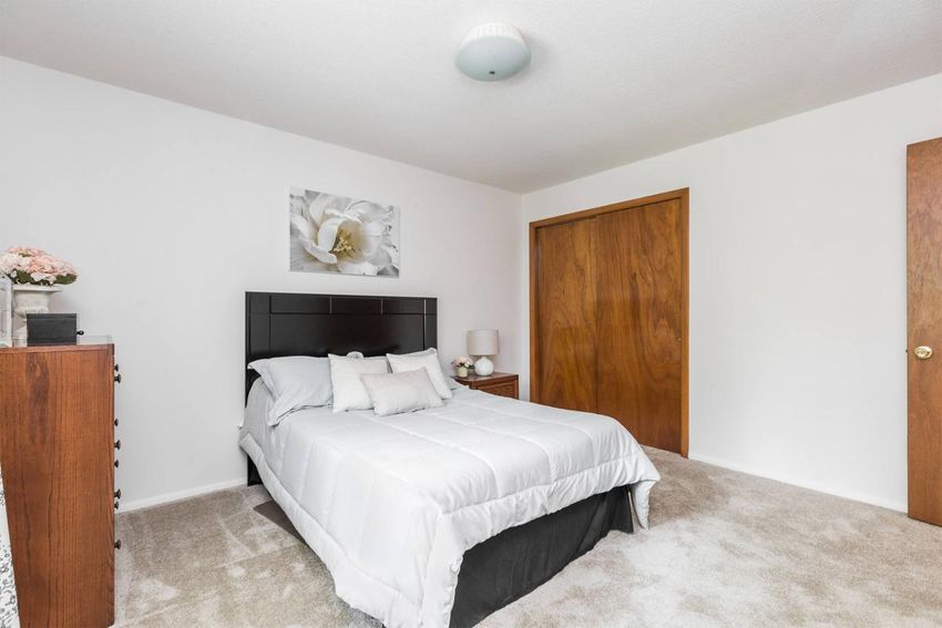 A bedroom with a large bed and a wooden door.