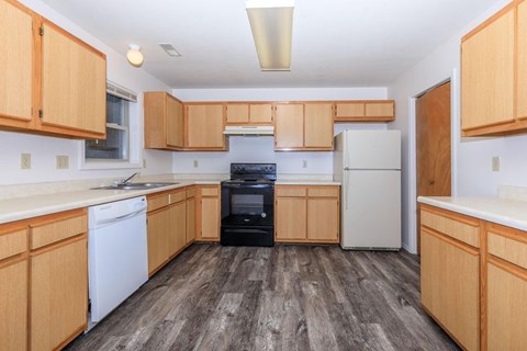 A kitchen with wooden cabinets and a black oven.