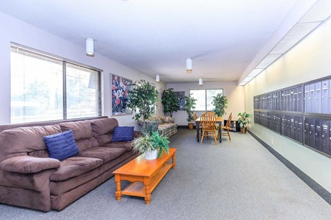 A living room with a brown couch, a coffee table, and a dining table with chairs.