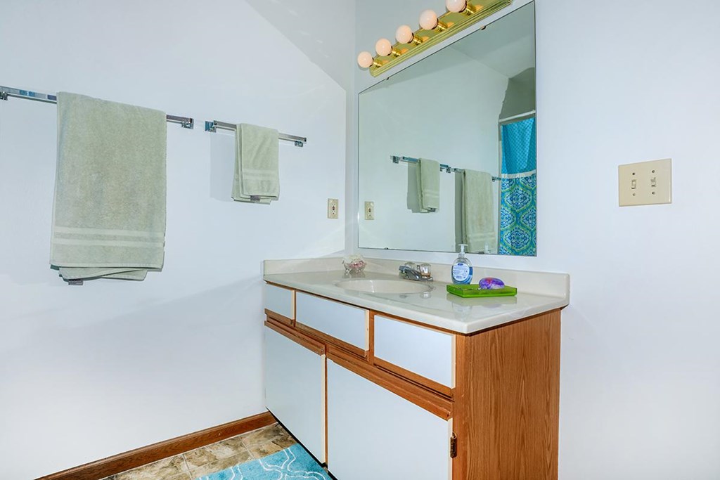 A bathroom with a white sink and a mirror above it.